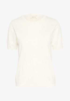 Vit kortärmad stickad topp med en strukturerad prickmönster, rund halsringning och en avslappnad passform. Etiketten säger "CREAM."