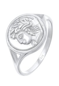Anello in argento con un emblema rotondo e rilievo che presenta un volto dettagliato, finitura liscia e accenti intagliati sulla fascia. Marcato 925 all'interno.