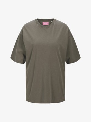 T-shirt oversized verde-oliva feito de algodão suave, apresentando um decote redondo clássico e mangas curtas, com um rótulo rosa no interior.