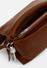 Borsa a tracolla in pelle marrone con apertura con zip, hardware in argento e tracolla removibile. Presenta tasche interne e una finitura testurizzata.