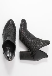 Woven black leather ankle boots with a pointed toe, open back, and textured block heel. Features a zip closure on the side.