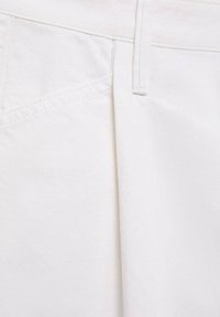 Tissu tissé blanc avec une texture lisse. Présente un design à plis à l'avant, une taille plate et des coutures visibles le long des coutures.