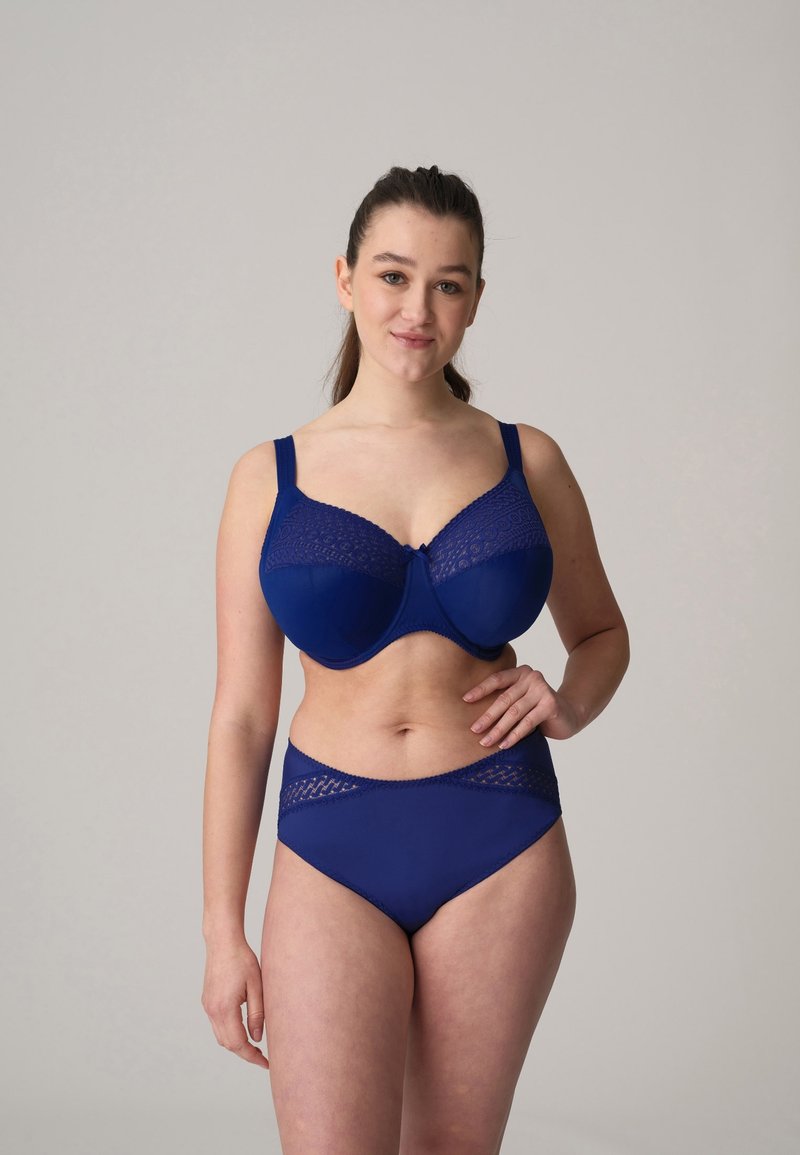 Conjunto de lencería azul marino que incluye un sujetador de cobertura completa con detalles de encaje y unas bragas altas a juego, fabricado con una tela lisa.
