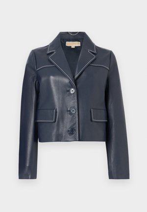 Μπλε ναυτικ ό κοντό δερμάτινο μπουφάν με λευκό διπλό γαζί, γιακά με εγκοπή, τρία κουμπιά μπροστά και δύο τσέπες με καπάκι.