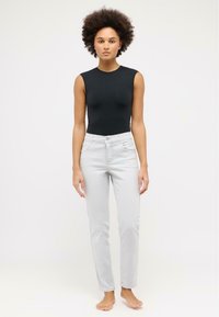 Black sleeveless bodysuit paired with light grey slim-fit jeans, featuring a classic button closure and minimalistic design.