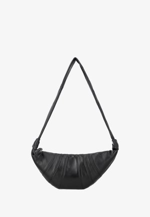 Zwarte leren schoudertas in halvemaanvorm met gestikte paneeldetails en een lange, geknoopte riem.