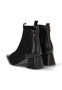 Botines negros con punta afilada, hechos de cuero y material elástico, con un tacón grueso y paneles laterales texturizados.