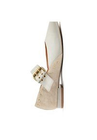 Zapato plano de ante beige y cuero blanco roto, que presenta una hebilla dorada y acentos de tachuelas, con un tacón de altura media y una textura suave.