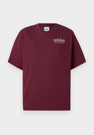 Burgundijos trumpomis rankovėmis marškinėliai, pagaminti iš medvilnės. Turi apvalų kaklą ir mažą baltą "adidas" logotipą su užrašu "SPORT DESIGN STUDIO" po juo.