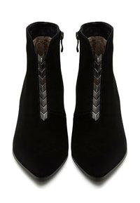 Botas de tobillo de ante negro con punta afilada, que presentan una fila vertical de accents de hardware negro brillante a lo largo del zipper frontal. Forro interior suave.