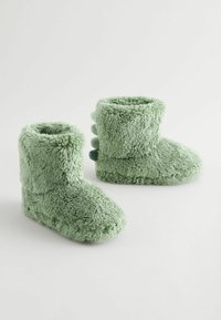 Grüne Plüsch-Booties mit einer weichen, flauschigen Textur; runde Zehenform; Rückseite mit drei Akzentdetails; gemütliches Design in Knöchelhöhe.