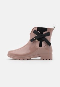 Botte de pluie rose brillante avec un intérieur noir texturé, ornée d'un nœud noir décoratif et d'accents dorés sur le côté. Semelle épaisse.