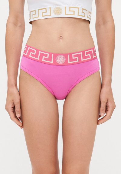 Ropa interior de algodón rosa con una cinturilla ancha que presenta un diseño geométrico y un logo. La banda se complementa con un top corto blanco en contraste.