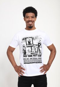 Bílý bavlněný tričko s černým grafickým potiskem postav a textu z "Vánoční noční můry", s výraznými ilustracemi a typografií.