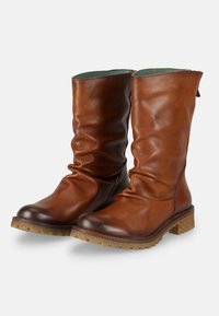 Botas de cuero marrón hasta la rodilla con un diseño holgado, acabado texturizado brillante y suela de corcho baja y texturizada.