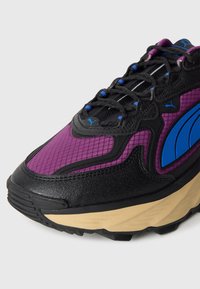 Sportovní boty s černým koženým a fialovým síťovaným svrškem, modrými akcenty, strukturovanou podrážkou a polstrovanou béžovou mezipodrážkou.