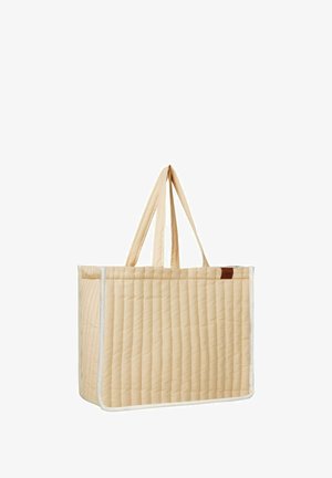 Bolso tote acolchado en beige claro con borde blanco; cuenta con dos asas largas y una forma rectangular. Superficie texturizada con costuras verticales.
