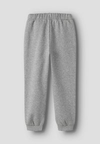 Ljusgrå sweatpants med elastisk midja och ärmslut, utlagda på en neutral bakgrund.