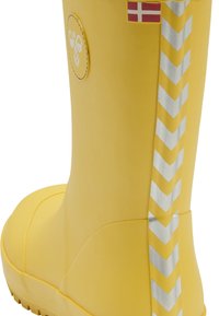 Žlutá gumová dešťová botka s hladkým povrchem, s stříbrným chevronovým pruhem a logem včely. Obsahuje malý akcent dánské vlajky.