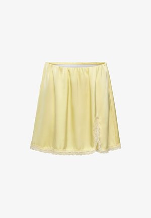 Demi-jupon en satin jaune clair avec ceinture élastique et bordure en dentelle à l’ourlet et à la fente latérale.