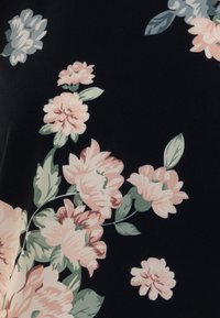 Tessuto floreale caratterizzato da grandi fiori rosa e crema con foglie verdi su uno sfondo nero, texture morbida e design fluido.