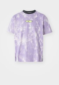 Violeta sietspala T-kreklā ar viļņotu batika rakstu, melnu apkakli un nelielu dzeltenu Nike logotipu vidū. Īsas piedurknes.