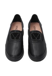 Zwarte instapschoenen van leer met een opvallende ronde zwarte suède patch versierd met kleine studs, met een gladde zool en een minimalistisch ontwerp.