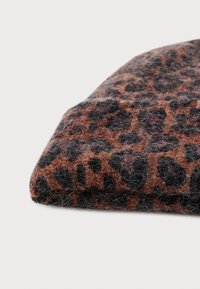 Tessuto con stampa leopardata in marrone e nero, caratterizzato da una superficie testurizzata e pelosa, di forma rettangolare e con bordo piegato.