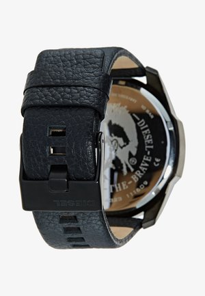 Zwarte lederen horlogeband met textuurafwerking, stalen kast en gegraveerde zwarte wijzerplaat met grafisch ontwerp. Gesp met "DIESEL"-branding.