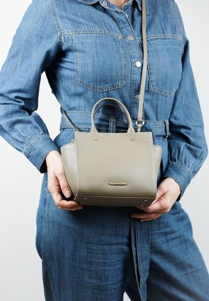 Graue Lederhandtasche mit doppelten Obergriffen, abnehmbarem Schulterriemen und goldfarbener Hardware. Rechteckige Form mit abgerundeten Kanten.