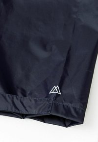 Námořnická tkanina s hladkým povrchem, obsahující bílý detail loga. Produkt má čistý design s dokonanými okraji a minimálním šitím.