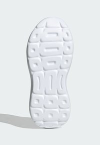 Biała gumowa podeszwa buta z fakturą, z zaokrąglonymi kształtami i rowkami zapewniającymi przyczepność. Gładka powierzchnia o jednolitej grubości.