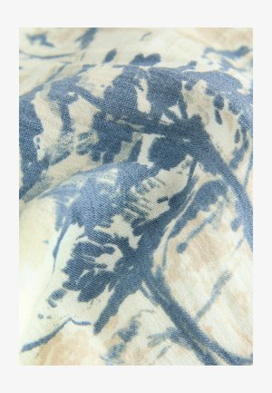 Blomstermønstrede stoffer med en struktureret overflade, der har blå og beige nuancer. Designet inkluderer varierende nuancer af blå på en lys baggrund.