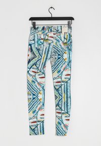 Leggings multicolori con un motivo geometrico blu, bianco, rosso e giallo. Realizzati in un tessuto elastico con una texture liscia.