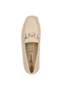 Beige instappers van zacht suede met decoratieve stiksels langs de rand en een metalen kettingaccent over de bovenkant.