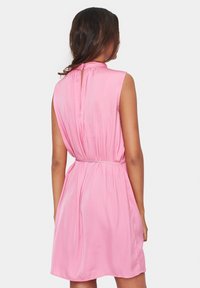 Vestido rosa sin mangas con un escote alto, cintura ceñida y un detalle de pliegues en la parte posterior. La tela parece suave y liviana.