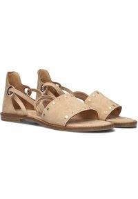 Beige suède sandalen met een brede band met gouden studs, open achterkant en elastische zijkanten voor een verstelbare pasvorm. Plat voetbed.