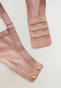 Lichtroze bh-band met een gaasontwerp, voorzien van gouden hardware en een haak-en-oogsluiting. Vlotte textuur met drie verstelopties.