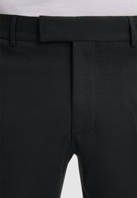 Zwarte broek van een gestructureerde stof, met een rechte voorkant, riemlussen en een standaard tailleband voor een getailleerde pasvorm.