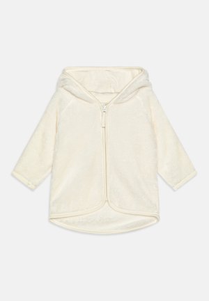 Cremefarvet blød fleece babysjakke med hætte og lynlås foran, lange ærmer og afrundet kant.