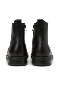 Stivali alla caviglia in pelle nera con finitura testurizzata, chiusura con zip e suole in robusta gomma nera, con dettaglio del logo impresso sul retro.