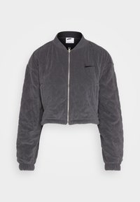 Geknipte grijze bomberjack gemaakt van zacht, gewatteerd materiaal. Voorzien van een rits aan de voorkant, ribbelkraag en elastische manchetten. Nike-logo op de borst.