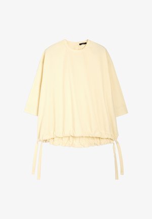 Żółta bawełniana bluzka z rękawami o długości trzech ćwiartek, zebranym dołem oraz regulowanymi sznurkami po bokach. Gładka tekstura i prosty wzór.