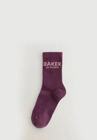 Fioletowa skarpetka dziana z ryżowym wzorem. Logo "BAKER" w jasnym różu wyszyte z boku. Wysokość do kostki z zaokrąglonym czubkiem.