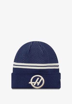 Granatowa dzianinowa czapka beanie z teksturowanym wzorem, białymi paskami i kremowym haftowanym logo na złożonym mankiecie. Miękki, rozciągliwy materiał.