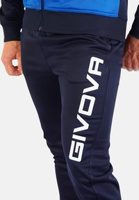 Sötétkék sportnadrág rugalmas anyagból, a bal lábszáron feltűnő fehér "GIVOVA" logóval és testhezálló szabással.