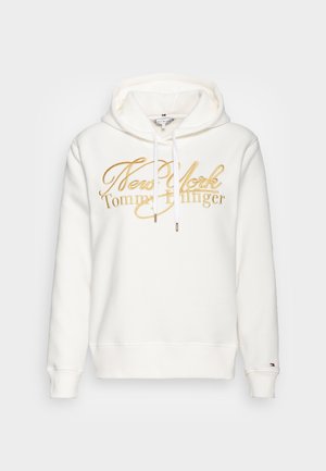 Sudadera blanca hecha de un tejido suave, con un logo bordado en dorado de "New York Tommy Hilfiger" y cordones para la capucha.