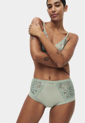 Miętowy zestaw bielizny z koronkowym biustonoszem o falistych krawędziach i materiałem z kropkowanej siateczki. Figi z wysokim stanem ozdobione koronkowymi akcentami.