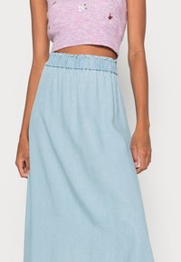 Lyseblå denim maxinederdel med en elastisk, rynket talje, glat tekstur og minimal detaljering. Designet til en afslappet pasform.