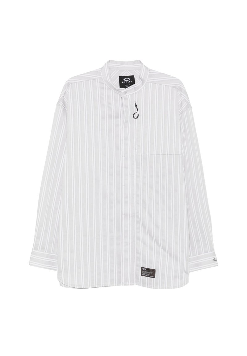 Camicia bianca a maniche lunghe con sottili righe verticali grigie, una piccola tasca frontale e un'etichetta nera vicino all'orlo e al colletto.